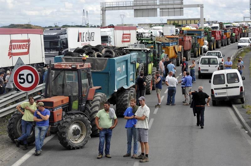 Ganaderos franceses durante el bloqueo de una carretera en protesta de la caída de los precios de los lácteos y la carne. Foto: EFE/Stephane Geufroi