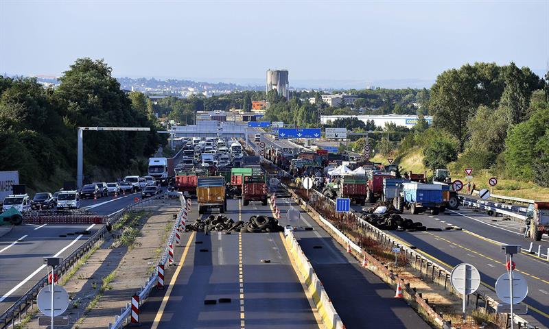 Ganaderos franceses bloquean con camiones y neumáticos una autopista en Limonest, cerca de Lyon (Francia). EFE/Stephane Guiochon.