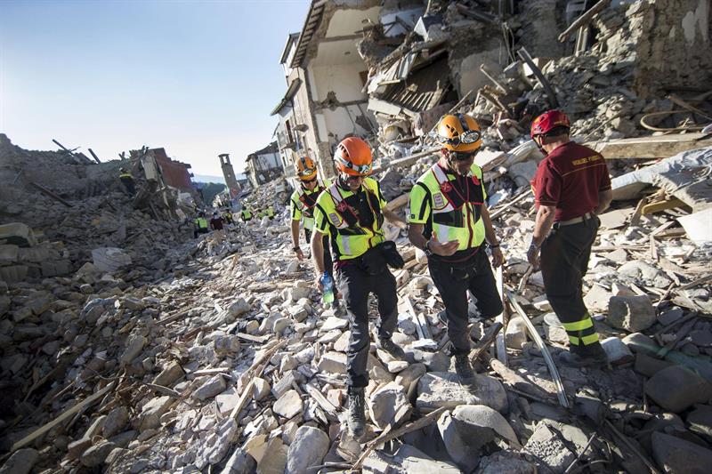 Agentes de rescate buscan entre los escombros de edificios derrudios en Amatrice, tras el terremoto. EFE/Massimo Percossi