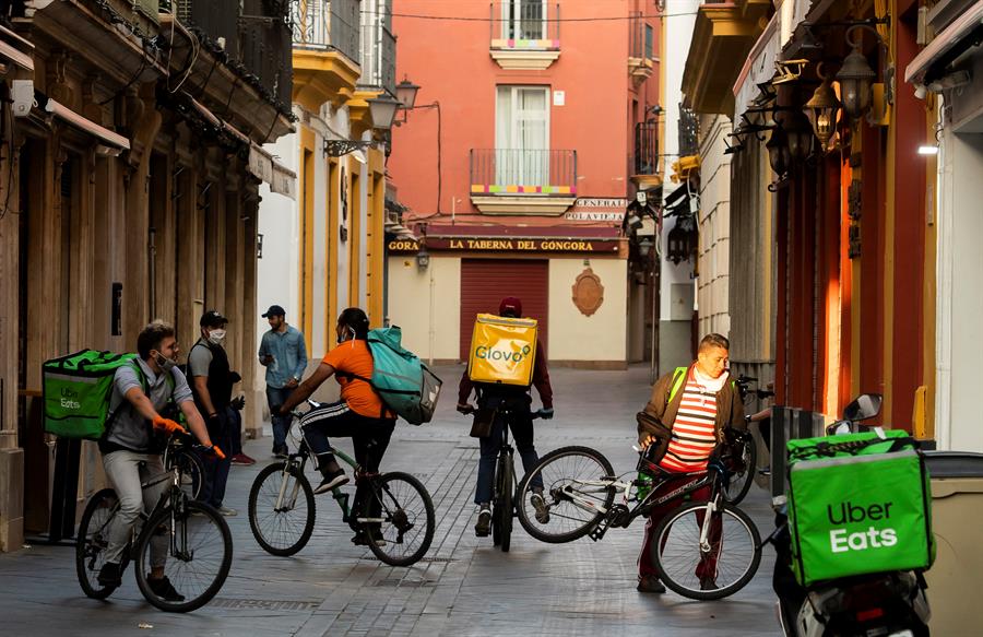 "Riders" con mochilas de varias compañías en Sevilla. Efeagro/Raúl Caro