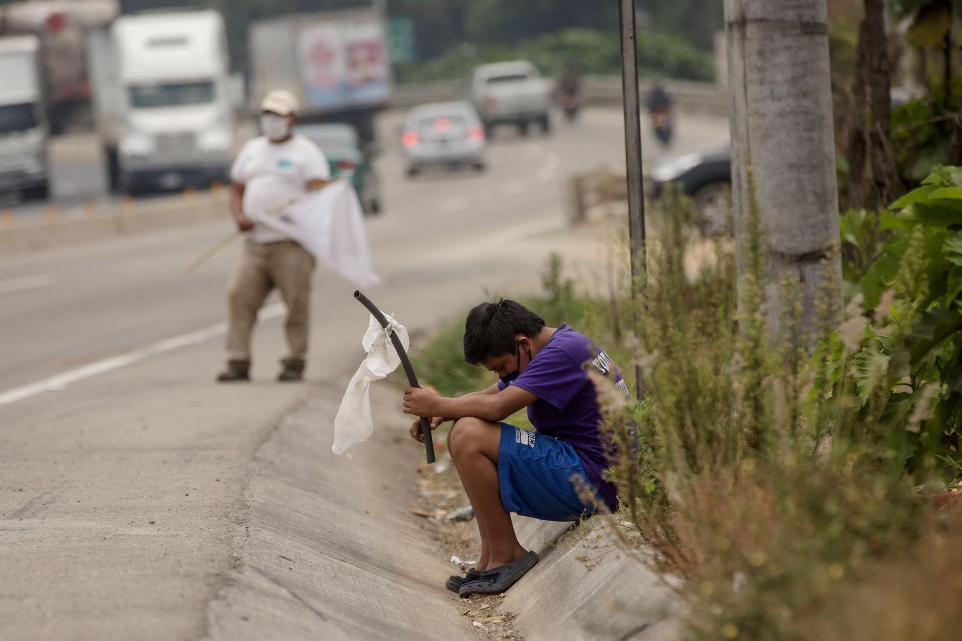 Un niño ondea una bandera blanca en la carretera pidiendo ayuda por hambre debido a la crisis economica provocada por el coronavirus en Guatemala. Efeagro/Esteban Biba