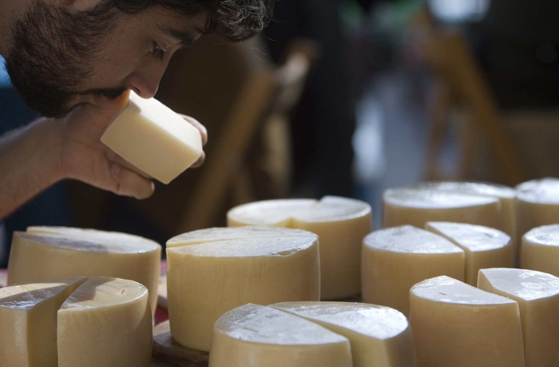 Un hombre huele un queso de Idiazabal. Foto: EFE/ADRIAN RUIZ DE HIERRO