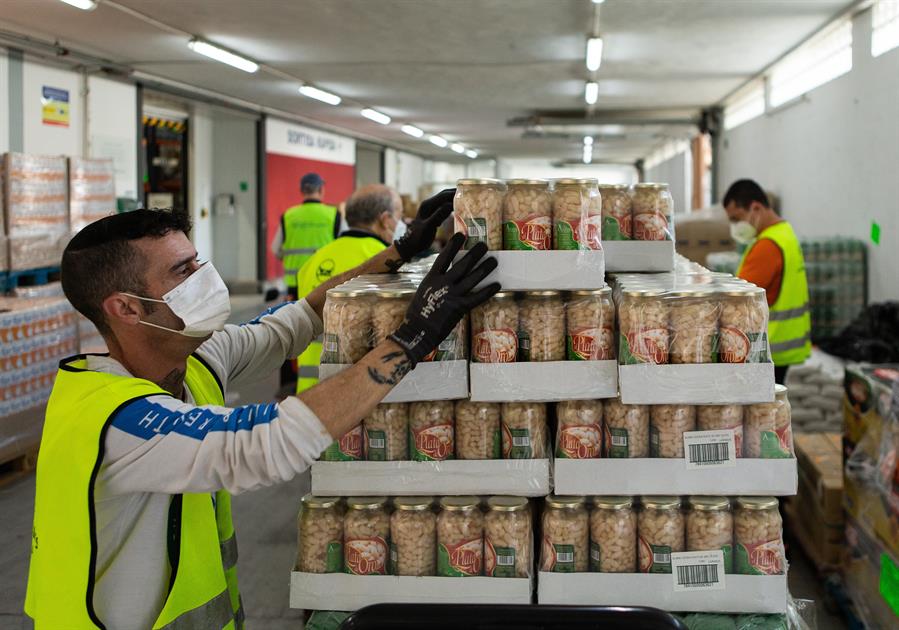 Varios voluntarios ordenan los pedidos en el almacén del Banco de Alimentos de Barcelona. Efeagro/Enric Fontcuberta
