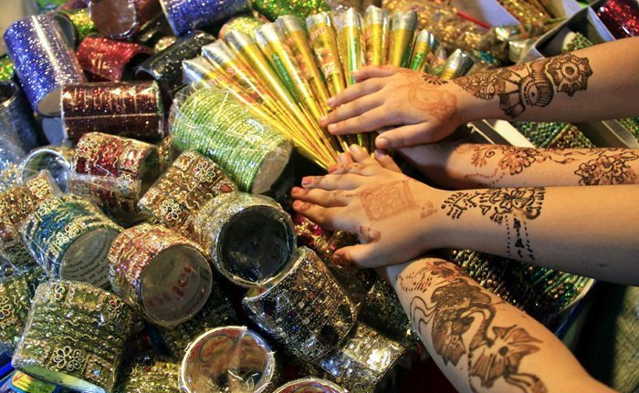 Chicas paquistaníes muestran sus manos decoradas con henna, antes de la festividad Eid al-Fitr, que marca el final del Ramadán. Foto: EFE/Arshad Arbab
