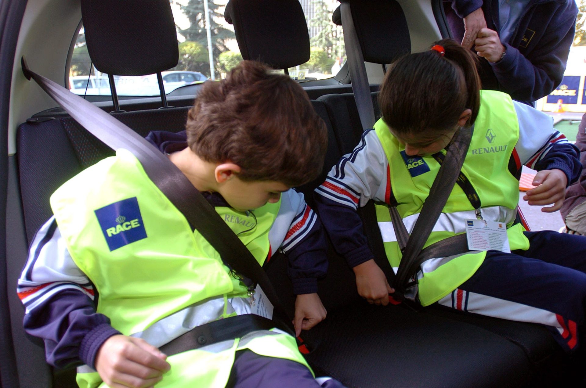 Dos niños se abrochan el cinturón de seguridad en la escuela de educación vial itinerante de RACE-Renault. EFE/Angel Díaz