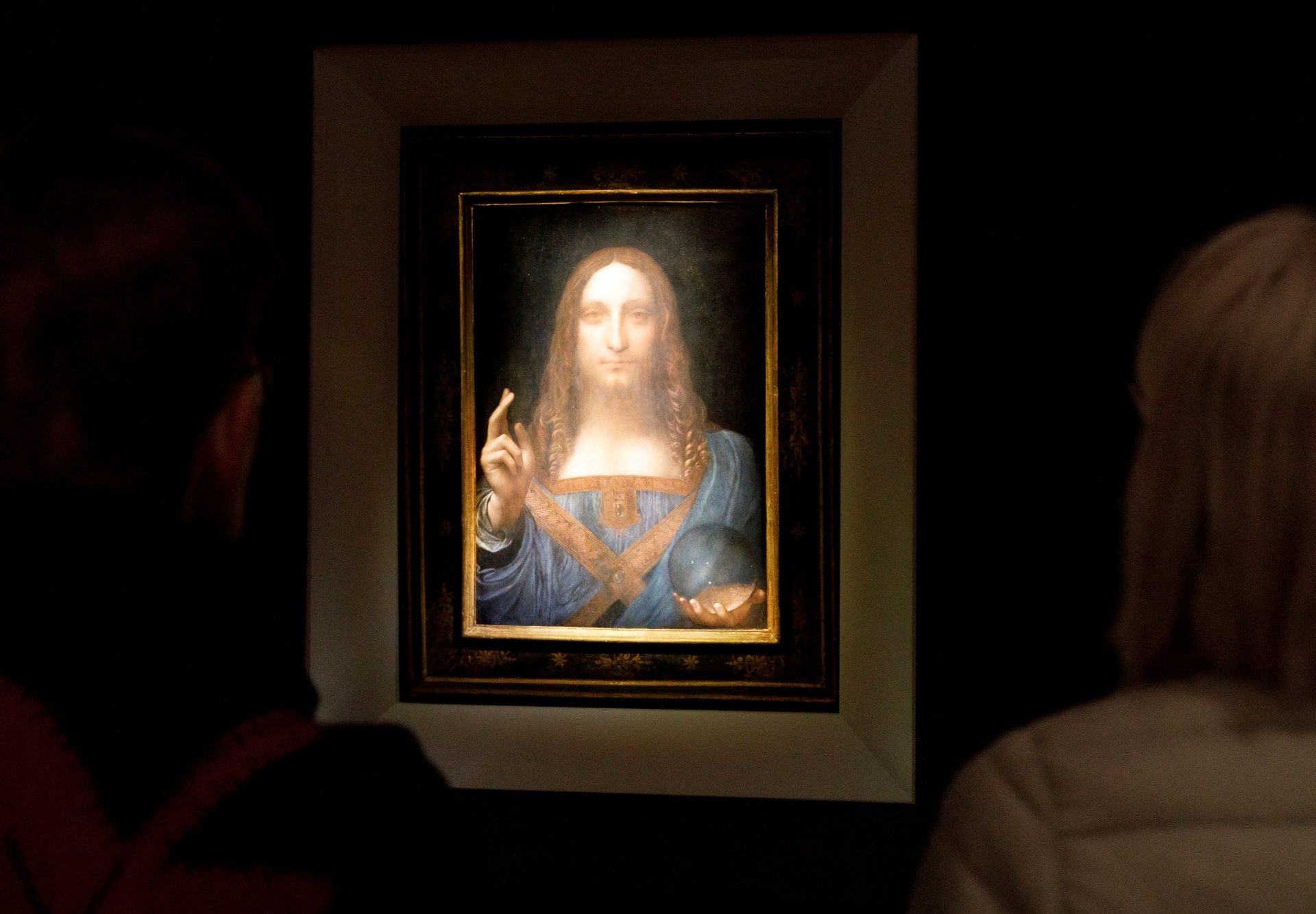 Varias personas observan la obra 'Salvator Mundi' del artista Leonardo da Vinci (1500). Foto: EFE/ Justin Lane