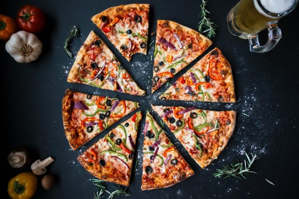 Imagen de una pizza junto a un vaso de cerveza. Efeagro