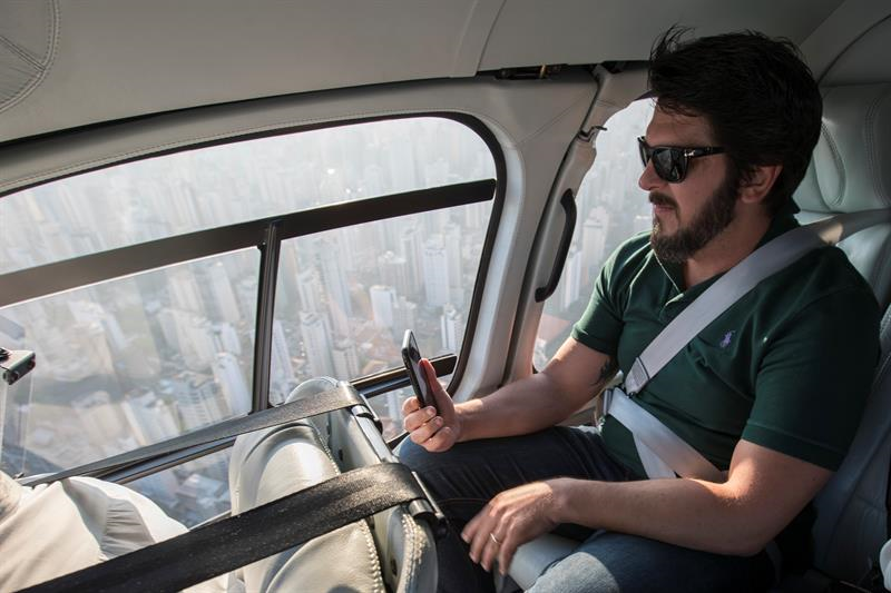 Un empresario frente a un helicóptero que pidió a través de la aplicación Cabify, en Sao Paulo (Brasil). Foto: EFE/Sebastião Moreira