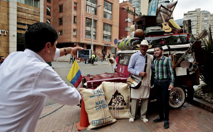 Dos caficultores se hacen una foto con sacos de cafés en Colombia. Efeagro/Juan Páez