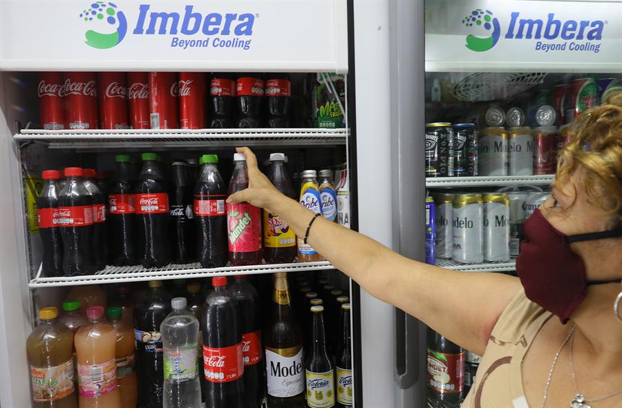 Una mujer compra bebidas azucaradas en una tienda de Ciudad de México (México). Efeagro/Alex Cruz