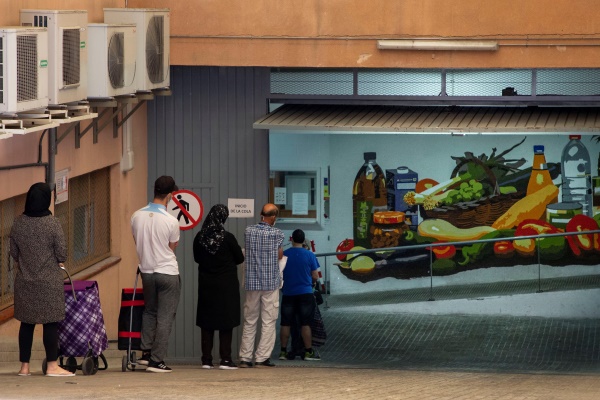 Imagen de archivo de varias personas haciendo cola para recoger alimentos en un almacén de Cruz Roja en Mataró (Barcelona). EFE/Enric Fontcuberta