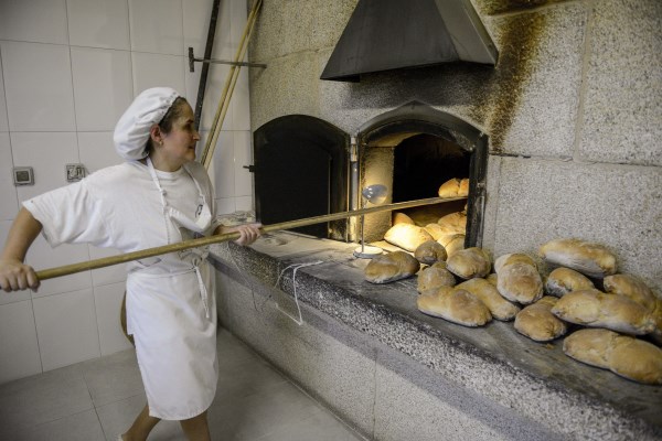 En la imagen Maria Ester Mosteiro, panadera del ""Forno Maruxa"", situado en el pueblo de Casasnovas (San Cristovo de Cea), retira piezas de pan tras su cocción. EFE//Brais Lorenzo