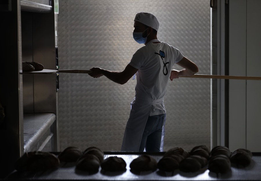 Un trabajador de la panadería de Cunha retira las barras de pan del horno en Carral, A Coruña.EFE/ Cabalar