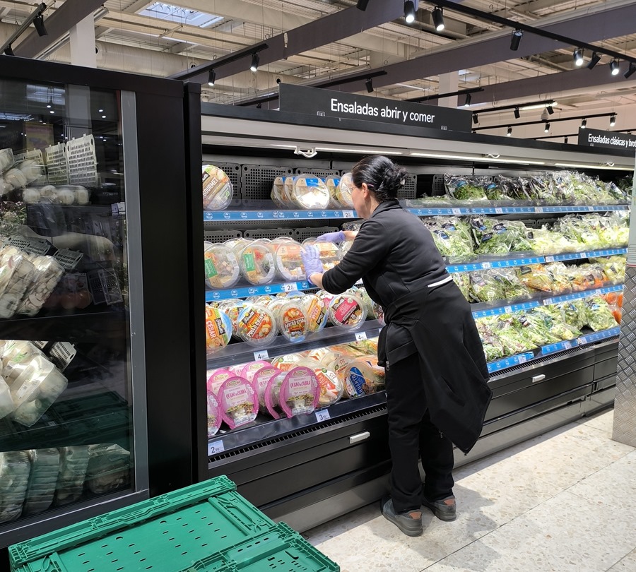Una reponedora coloca ensaladas para llevar en las estanterías de las cámaras frigoríficas de un supermercado. EFE/Paloma Puente